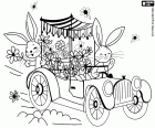 Due coniglietti pasquali in un'auto d'epoca che disemano fiori per festeggiare la Pasqua